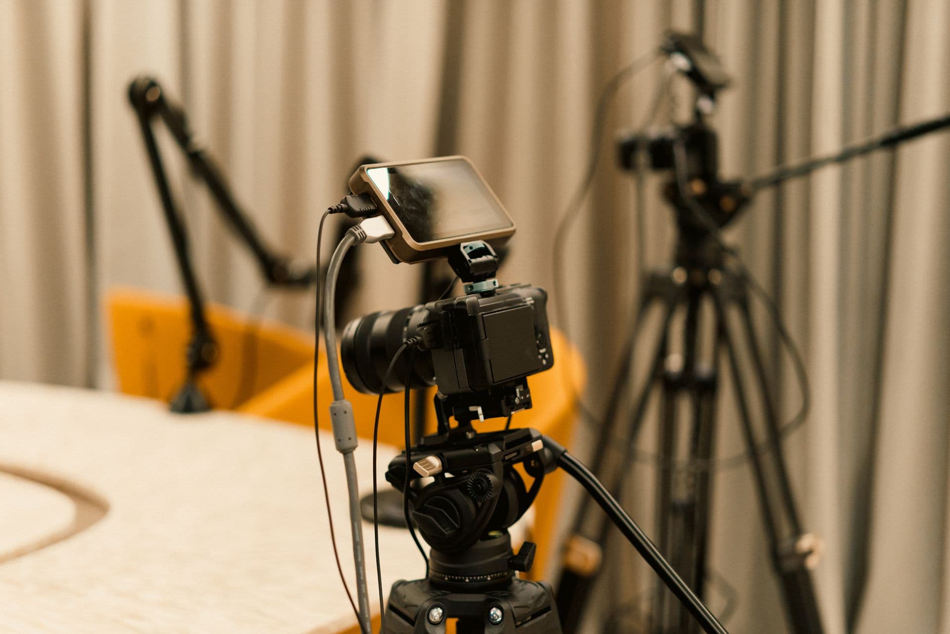 Setup de gravação de videoaula: câmera, monitor, microfone boom e tripé