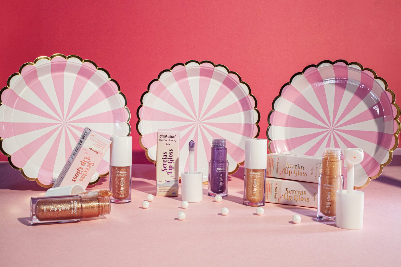 Linha Metoo Sereias Lip Gloss completa com pratos listrados, still de produto em estúdio em BH